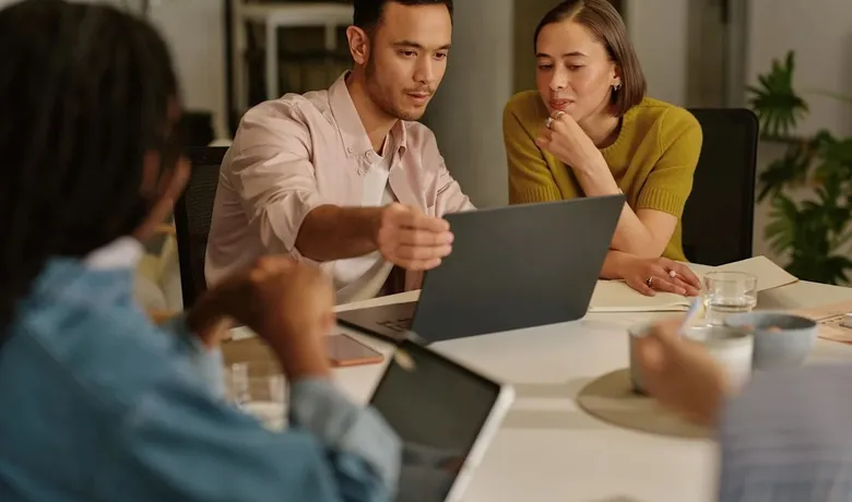A team gathered around a laptop in a meeting